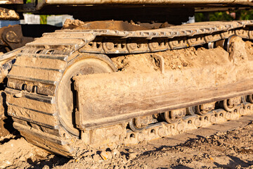 Close-up of metal tracks of a crawler crane with steel wheels. Chassis of tracked vehicles. Track...