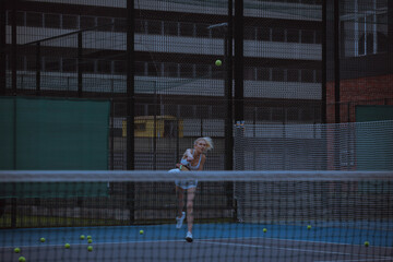 Woman tennis player trains on the tennis court.