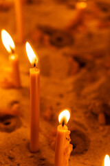 A lot of burning candles in the temple in the dark. The concept of religion, prayer and God.