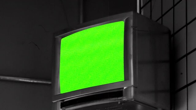 Retro TV Green Screen Wall Old Film Texture Tilt Down Vintage Style. Old television on a wall with green screen statics, tilt down. Vintage style, black and white