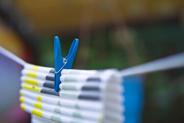 colorful plastic clothespin holding the washer on a string stretched in the garden            