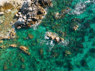 Italy, July 2023: aerial view from the drone of the caribbean sea with colors ranging from turquoise to light blue at the Baia di Riaci near Tropea in Calabria