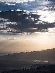 Scenic view from the slopes of the mountain at sunset in the evening with low clouds, evening nature panorama