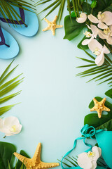Summer flat lay background. Palm leaves, hat, flip flop and shells on blue. Summer composition with space for design.