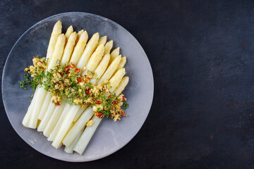Traditional Bavarian white asparagus with wild garlic- and almond butter served as top view on a...