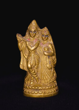 Antique brass made mini sculpture of Hindu mythological figure Radha and Krishna isolated on black background 