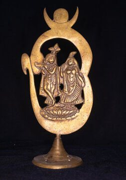 Antique brass made mini sculpture of Hindu mythological figure Radha and Krishna isolated on black background 