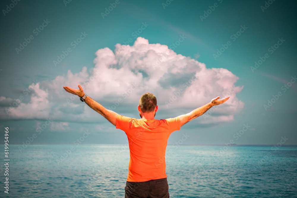 Wall mural man looking at sunset cloud over tropical sea freedom