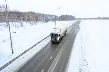 A semi-trailer truck, semitruck, tractor unit and semi-trailer to carry freight. Cargo transportation in harsh winter conditions on slippery, icy and snowy roads.