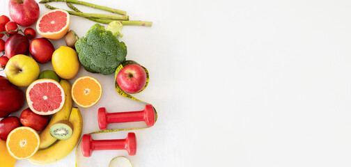 Fresh tasty organic fruits and vegetables, dumbbells on white studio background, panorama