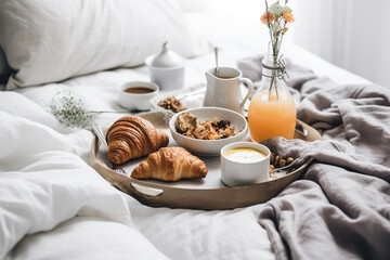 Fototapeta na wymiar French sweet breakfast in a bed, croissants, juice, coffee. Generative AI