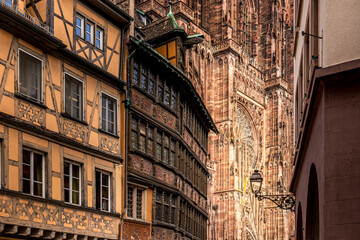 Strasbourg, France - June 19, 2023: Strasbourg Cathedral seen from the cathedral square with old half timbered houses