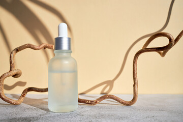 Bottle of face cosmetic, serum, vitamins or retinol on a beige background. Facial care. Organic...