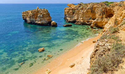Atlantic rocky coast view and sandy beach Praia de San Rafael with limestone cliffs, Albufeira, Algarve, Portugal
