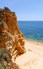 Fototapeta na wymiar High orange cliff and the sandy beach, Algarve, Portugal