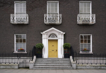 Old fashioned Georgian style townhouse with bright yellow front door - obrazy, fototapety, plakaty