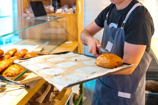 Bakery baker in workshop workshop of artisan bakery and shop placing croissant and neapolitan