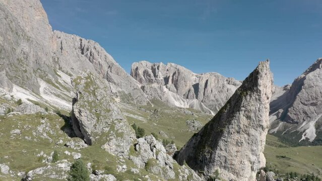 Aerial drone reveal rotation of a peaceful mountain top rock formation in the middle of an alpine meadow in the Italian Alps 03