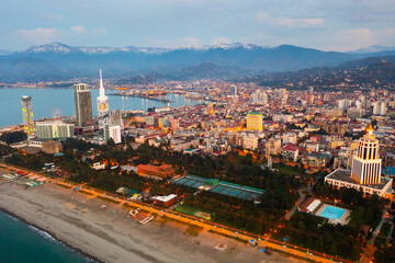 Scenic view from drone of seaside area of Batumi overlooking buildings of modern hotels and high-rise tower of Technological University on spring twilight, Georgia..