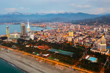 Fototapeta premium Scenic view from drone of seaside area of Batumi overlooking buildings of modern hotels and high-rise tower of Technological University on spring twilight, Georgia..