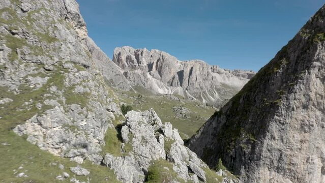 Aerial drone flying through a peaceful mountain top rock formation in the middle of an alpine meadow in the Italian Alps 01