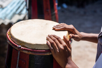 Hands of a musician standing still on a Brazilian atabaque.