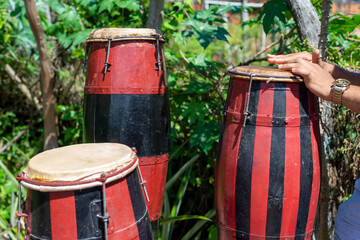 Hands of a musician standing still on a Brazilian atabaque.