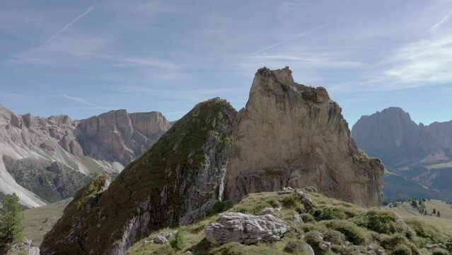Aerial drone reveal rotation of a peaceful mountain top rock formation in the middle of an alpine meadow in the Italian Alps 01 