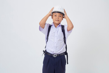 A young Asian cute boy standing in a Thai school uniform with a backpack bag and safety helmet  on a white background banner