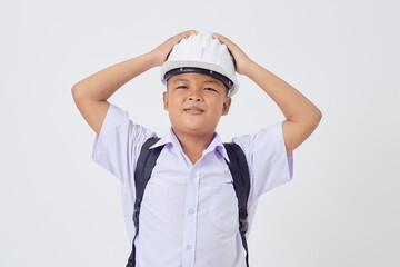 A young Asian cute boy standing in a Thai school uniform with a backpack bag and safety helmet  on...