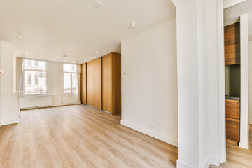 Obraz na płótnie Canvas an empty living room with wood flooring and large windows in the room is white walls, hardwood floors and wooden doors