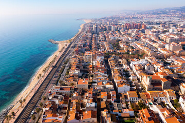 Picturesque drone view of modern Vilassar de Mar cityscape on Mediterranean coast on sunny winter day, Spain..