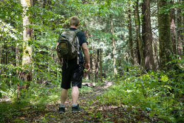 Naklejka na ściany i meble Hiker with backpack in the woods, hiking shoes, copy space vacation summer activities backgrounds