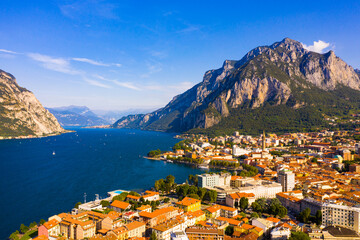 Colorful mountain scenery with Italian city of Lecco on shore of picturesque Lake Como on sunny day, Italy
