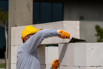 The bricklayer is working. Building a wall of aerated concrete. Gasbeton wall