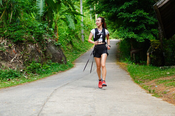 Selective focus of Asian woman exercising, running, running in the midst of shady nature