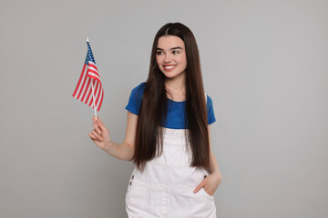 4th of July - Independence Day of USA. Happy girl with American flag on grey background