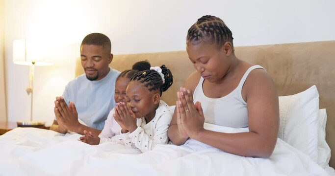 Black family, parents and children praying in bed for religion, worship God and faith at night. Spiritual, Christian and mother, father and girls in prayer for faith, gratitude and hope in bedroom