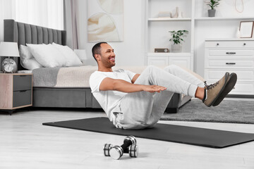 Man doing morning exercise on fitness mat at home