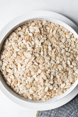 Top view of nigerian egusi seeds in a white bowl, shelled melon seeds in a bowl, nigerian melon seeds, pumpkin seeds for cooking