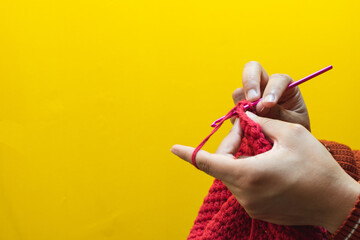 Detail of hands knitting with a crochet needle - obrazy, fototapety, plakaty