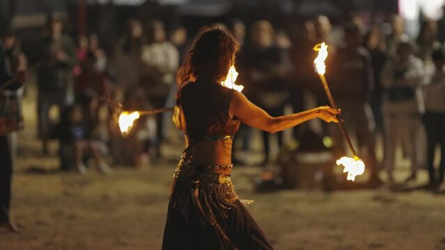 A woman performing a fire show at the street