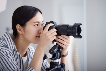 ファッション写真撮影を行う20代の日本人女性カメラマン - obrazy, fototapety, plakaty