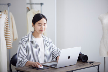 ノートパソコンを使用する20代の日本人女性カメラマン
