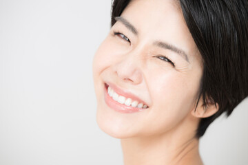 Obraz premium Easy to use in beauty style Close-up of a beautiful Asian (Japanese) woman looking at the camera with a cute smile.