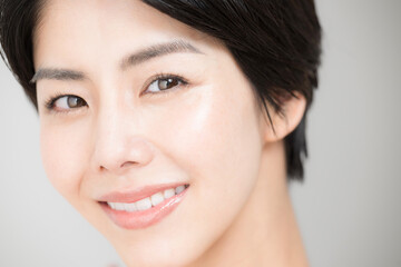 Naklejka premium 美容系で使いやすい かわいい笑顔でカメラを見つめる美しい女性のアップ