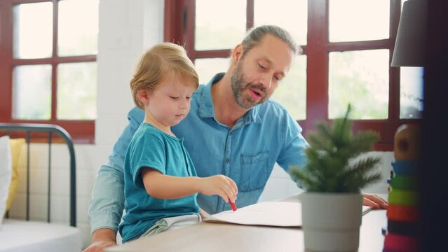 Caucasian attractive father use laptop computer with young son beside.
