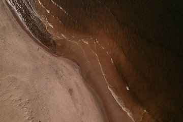 Drone aerial view of waves sea ocean coast. Beach and dunes dark calm sea waves nature landscape captured with drone. Tourism in Poland