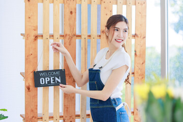 Asian happy cheerful professional beautiful female florist designer shop owner in apron open floral garden store studio.