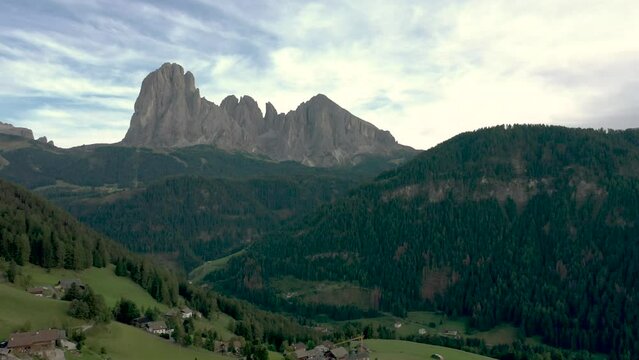 Aerial drone shot of a catholic church top cross with the Italian dolomites alps mountains in the background 02